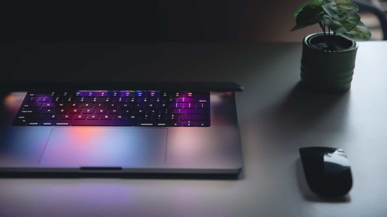 Beleuchtete Laptop-Tastatur auf einem abgedunkelten Schreibtisch als Symbol für WordPress-Updates und Website-Wartung